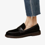 Bild på en klassisk svart loafer i mocka för kvinnor med rem, bärs med jeans