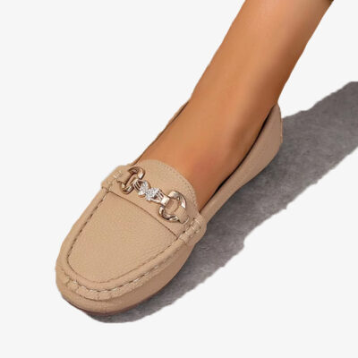Beige loafers i syntetläder med kedja och strassfjäril på vit bakgrund